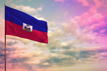 Fluttering Haiti flag mockup with the space for your content on colorful cloudy sky background.