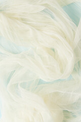 Obraz premium Yellow silk soft fabric on blue background. Elegant and delicate wallpaper