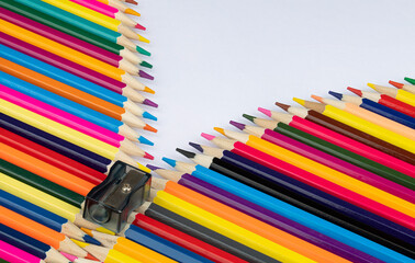 Background photo of colored pencils and a sharpener forming an imaginary zipper.