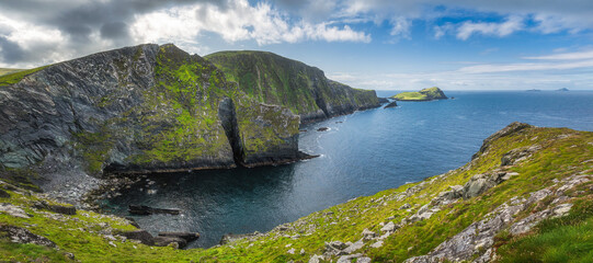 Large panorama with tall Kerry Cliffs and a view on Skellig Michael island where Star Wars were...