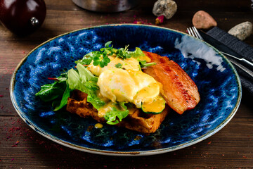 Poached egg on toast, with smoked bacon, and salad