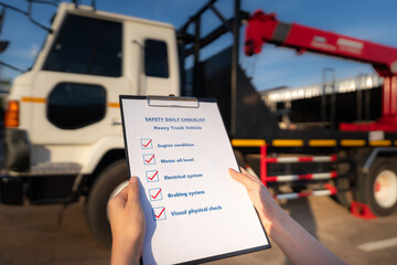Action of mechanic worker is using the daily checklist form to verify and inspection a heavy truck...