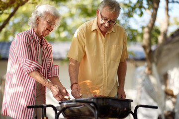 elderly couple making barbeque