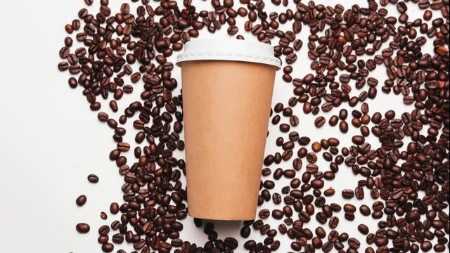 Stop motion video of paper coffee cup and fresh roasted coffee beans