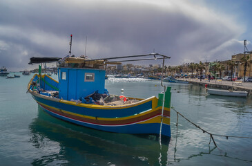 Fototapeta na wymiar Marsaxlokk Fishermen Village In Malta. Traditional Colorful Boats At The Port Of Mars
