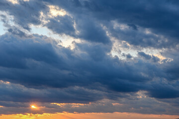 Stormy sky with storm clouns on the sunset with beautiful sun