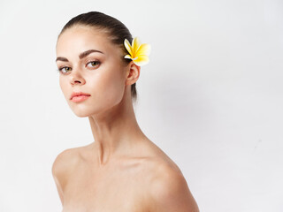Fototapeta premium romantic woman with yellow flower in hair naked shoulders clear skin model