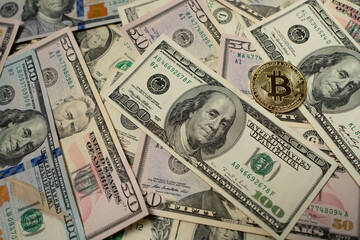 Bitcoin on dollar banknotes. One hundred dollar bill next to gold bitcoin coin. Crypto exchange...