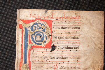 A medieval manuscript hand written onto parchment or vellum and illuminated with red initial flourishes in pen. Many manuscripts were used in the C15th and C16th as binder's waste for bookbinding.