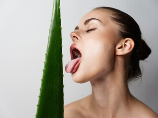 woman with closed eyes licks aloe leaf and makeup on face cropped view model