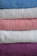 Multi-colored cotton terry towels are stacked