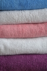 Multi-colored cotton terry towels are stacked