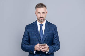 confident businessman man in suit typing text message on phone, blogging