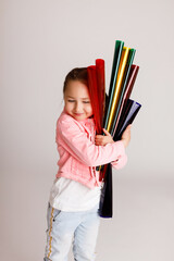 Preschool girl hugging colored foil tubes and learning colors, early development and learning concept