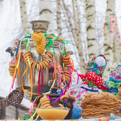 Festively decorated table for the Maslenitsa holiday with a samovar and pancakes