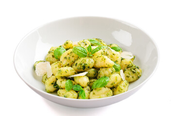 Gnocchi with pesto sauce isolated on white.