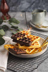 Breakfast waffles with chocolate with golden silverware on grey surface