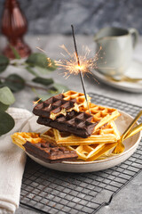 Breakfast waffles with chocolate with golden silverware on grey surface