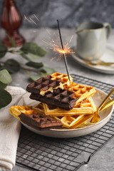 Breakfast waffles with chocolate with golden silverware on grey surface