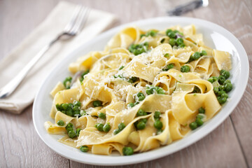 Tagliatelle pasta with cream and peas on a plate.