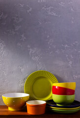 Empty colorful crockery or ceramic dishes set. White kitchen dishware and tableware on wooden table