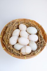 Duck eggs in bamboo basket on white background