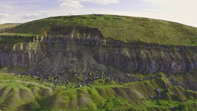 4K Aerial drone view flying over the disused quarry in a green, rural landscape Llangattock Escarpment, Wales, UK