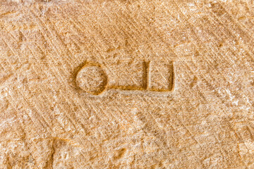Stonework symbol in the shape of a key lying on the wall of the 12th century Cistercian monastery of Santa María de Moreruela. Zamora. Spain.