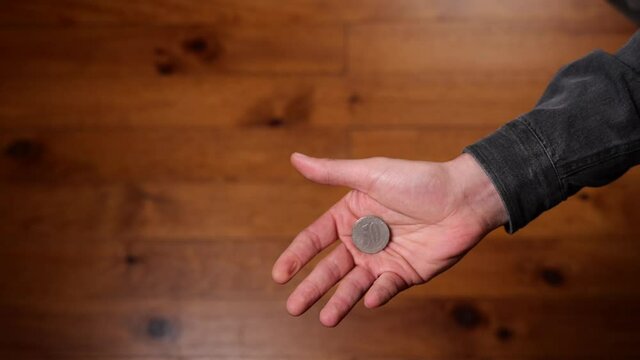 Flip coin to heads or tails on wooden background. Slow-motion and high angle