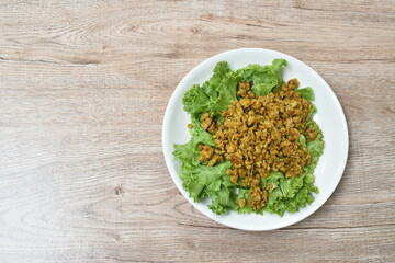spicy fried chop pork with turmeric and curry on lettuce Thai southern style food in plate