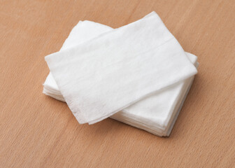 Stack of unwrapped wet wipes on wooden table - obrazy, fototapety, plakaty