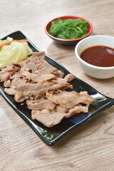 Korean fried slice pork with cabbage on plate dipping sauce and seaweed in sesame oil salad