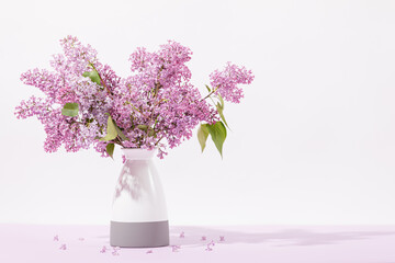 Bouquet of fresh purple lilac flowers in ceramic vase