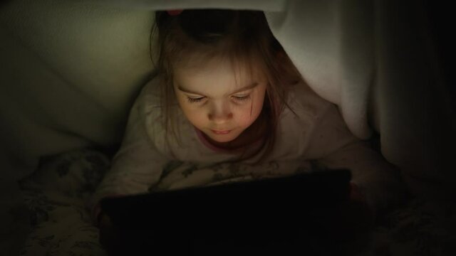 Girl watching film on tablet at night