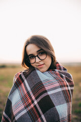 Fille avec un plaid au coucher du soleil