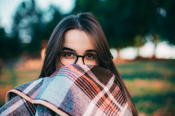 Fille avec un plaid au coucher du soleil