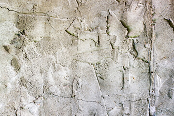 Grunge concrete cement wall with bumps and cracks in industrial building, great for your design and background texture. Copy space.