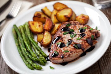Fillet of beef with potatoes and asparagus on a plate.