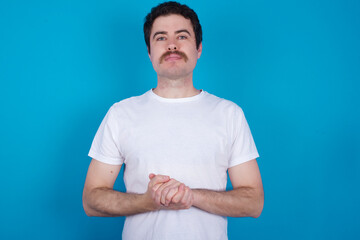 young handsome Caucasian man with moustache wearing white t-shirt against white background got back pain