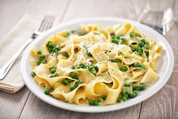 Tagliatelle pasta with cream and peas on a plate.
