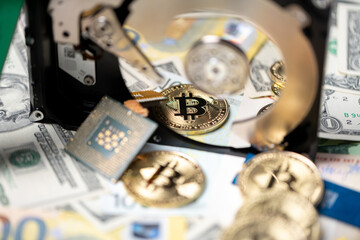 Bitcoin on dollar and euro bills reflecting on hard drive disk. Concept of storing crypto blockchain. Price of crypto mining and trading digital assets