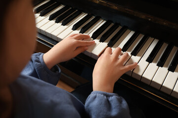Fototapeta premium Little child playing piano, closeup. Music lesson