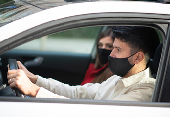 Masked couple in their car, covid coronavirus concept