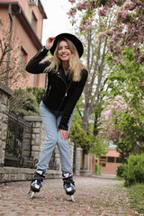 Young woman roller skating on spring day