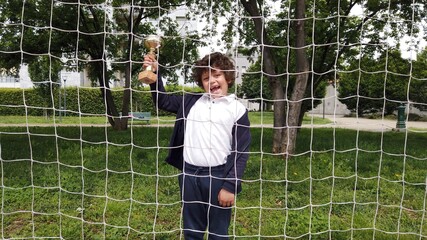 6-year-old boy wins a cup playing his favorite football  sport - return to children's sports and competition after quarantine and lockdown due to Covid-19 Coronavirus 