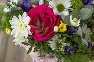 Close up bouquet with red rose, purple irises and white, yellow, green chrysanthemums. floral background.