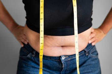 Caucasian Woman With Belly Fat Using Tape Measure