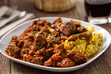Polenta and beef stew on a plate. High quality photo.