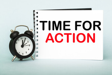 A words TIME FOR ACTION on notebook with clock. Concept for time management and business.