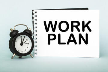 A words WORK PLAN on notebook with clock. Concept for time management and business.